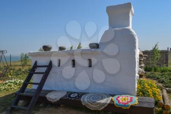 Russian Cossack outdoor oven. Stove with wood, whitewashed with lime. Outdoor oven for cooking food.