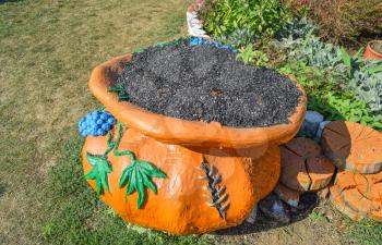 Clay pot in the form of a bag of sunflower seeds. The bag on the grass.