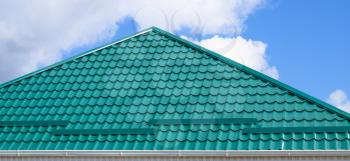 The roof of corrugated green sheet. Roofing of metal profile wavy shape.