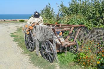 Mannequin fisherman in the wagon. The wagon with fishing nets and fisherman doll with a beard.