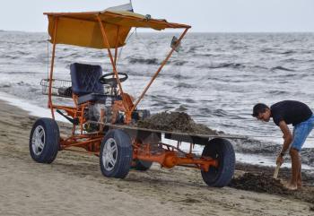 The car for garbage collection from the beach. Cleaning on the beach, clean beach from mud and waste.