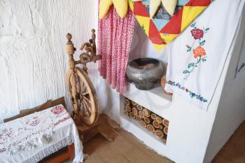 Interior Cossack home. Spinning Wheel, oven, kettle, firewood oven and whitewashed walls
