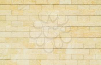 Background of yellow bricks. Wall of yellow bricks. The texture of the wall