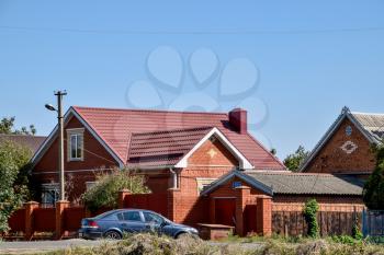 village Poltavskaya, Russia - August 20, 2016: Detached house with a roof made of steel sheets. Roof metal sheets. Modern types of roofing materials.