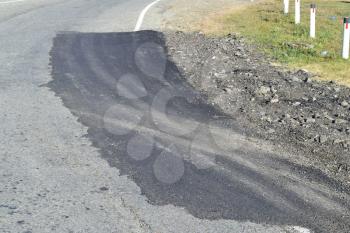 Repair of an asphalt road surfacing. A patch on asphalt.