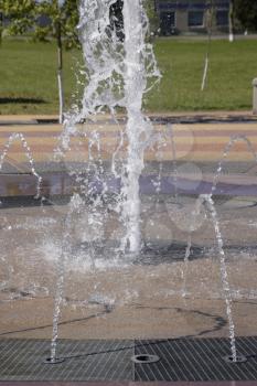 Splashes of a fountain in the park. Beautiful water jet emitted fountain.