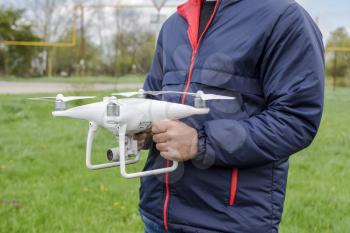 A man with a quadrocopter in his hands. A white drone is being prepared for the flight. Phantom