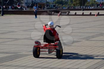 Novorossiysk, Russia - September 29, 2018: Children ride in the park on cars with pedals. Admiral Serebryakov Square. Childrens leisure.