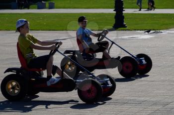 Novorossiysk, Russia - September 29, 2018: Children ride in the park on cars with pedals. Admiral Serebryakov Square. Childrens leisure.
