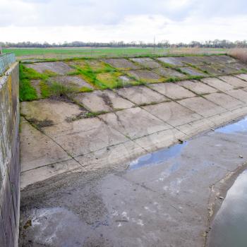 Paved concrete banks of the irrigation canal at the outlet of the water pumping station.