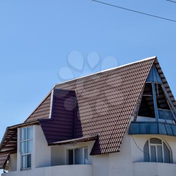 Detached house with a roof made of steel sheets. Roof metal sheets. Modern types of roofing materials.