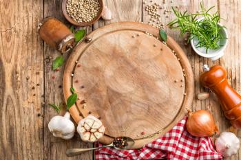 culinary background with empty cutting board and spices on wooden table