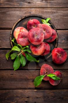 Peach, saturn or donut peaches with leaves