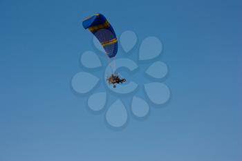 paraglider with a motor in blue sky