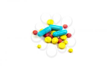Colored pills, tablets and capsules on a white background