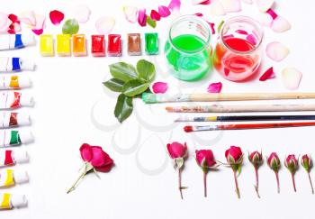 Workplace artist, designer. Paints, brushes, flowers and roses. Concept art and inspiration. Top view, flat