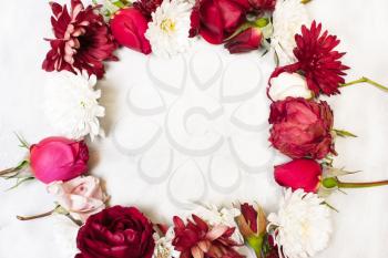 frame of flowers. Decorations of red roses, buds, green leaves and white chrysanthemums . View from above, flat