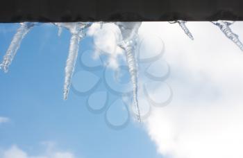 Icicles hanging from the roof of the ice against the sky