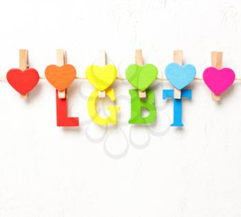 The word LGBT from multicolored letters on a white background, hearts in rainbow symbolism