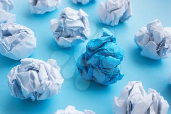  blue wrinkled ball of paper among the whites. Concept of ideas, differences, leadership. View from above, flat