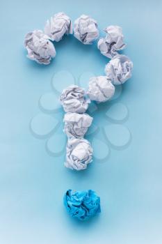 Question mark from crumpled white and blue paper balls. Concept ideas. View from above, flat