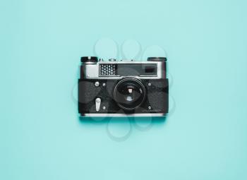 Vintage old photo camera on a blue background. Retro concept. View from above, flat