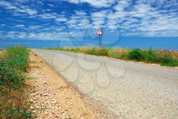 Long road in desert and  traffic sign. Nature composition.