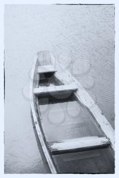 Fine art image in black & white. A wooden boat on a misty lake.