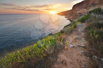 Footpath in mountains above the sea at sunset. Scenic landscape