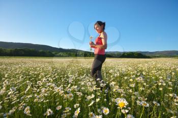 Happy girl in daisy wheel spring flower field. Emotional and nature scene.