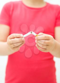 Young girl is breaking a cigarette, quit smoking concept