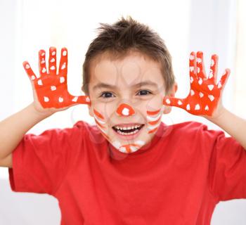 Portrait of a cute boy showing her hands painted in bright colors