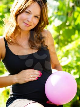 Image of pregnant woman touching her belly with hands