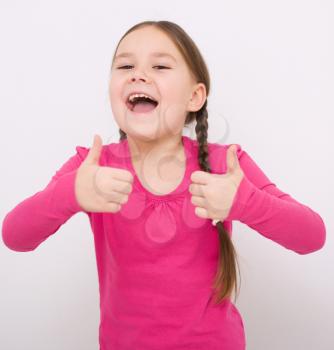 Little girl dressed in blue is showing thumb up gesture using both hands