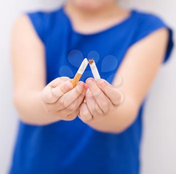 Young girl is breaking a cigarette, quit smoking concept