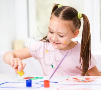 Portrait of a cute cheerful girl showing her hands painted in bright colors