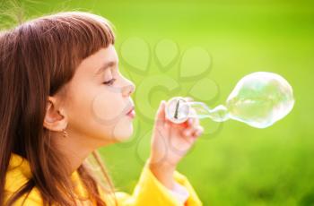 Portrait of cute girl blowing soap bubbles