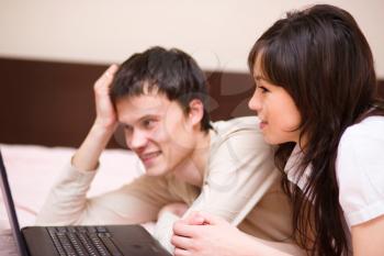 Young couple is playing on laptop, indoor shoot