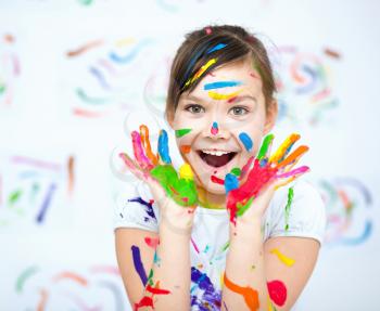 Cute girl showing her hands painted in bright colors