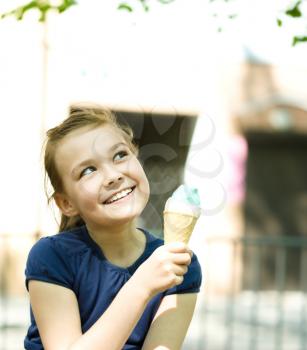 Cute happy girl is eating ice-cream