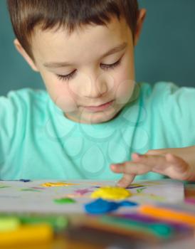 Happy boy playing with color play dough