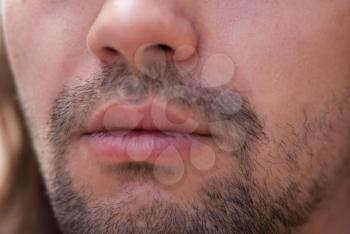 Part of face young European man with beard. Smiles.