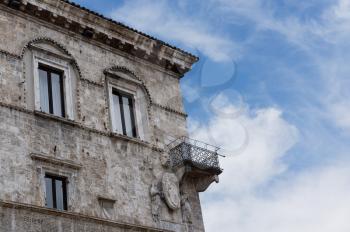 Details of architecture, historical buildings of Italy. Stone walls and stone mask. Ascoli Piceno. Marche.
