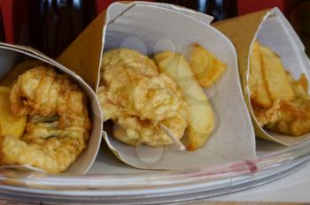Shrimps, potatoes and vegetables in batter, fried . Street food in cardboard package. Roast, fries fish and vegetables.