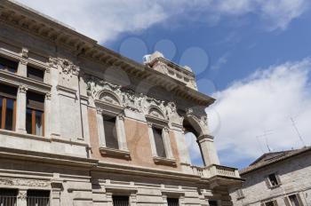 Details of architecture, historical buildings of Italy. Stone walls and stone mask. Ascoli Piceno. Marche.