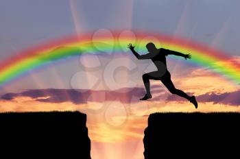 Jump runner athlete. Runner jumps over a precipice on the background of the rainbow