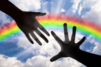 Helping hand concept. Helping Hand of God against the backdrop of a rainbow sky