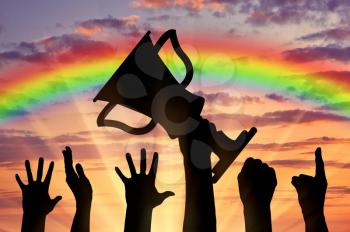 Winning the cup sport. Human hands holding the cup on the background of rainbow sunset