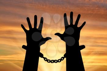 Freedom concept. Silhouette of human hands in handcuffs against the sky