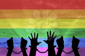 Discrimination against gay rights. Silhouette of hands in handcuffs on the background of the rainbow